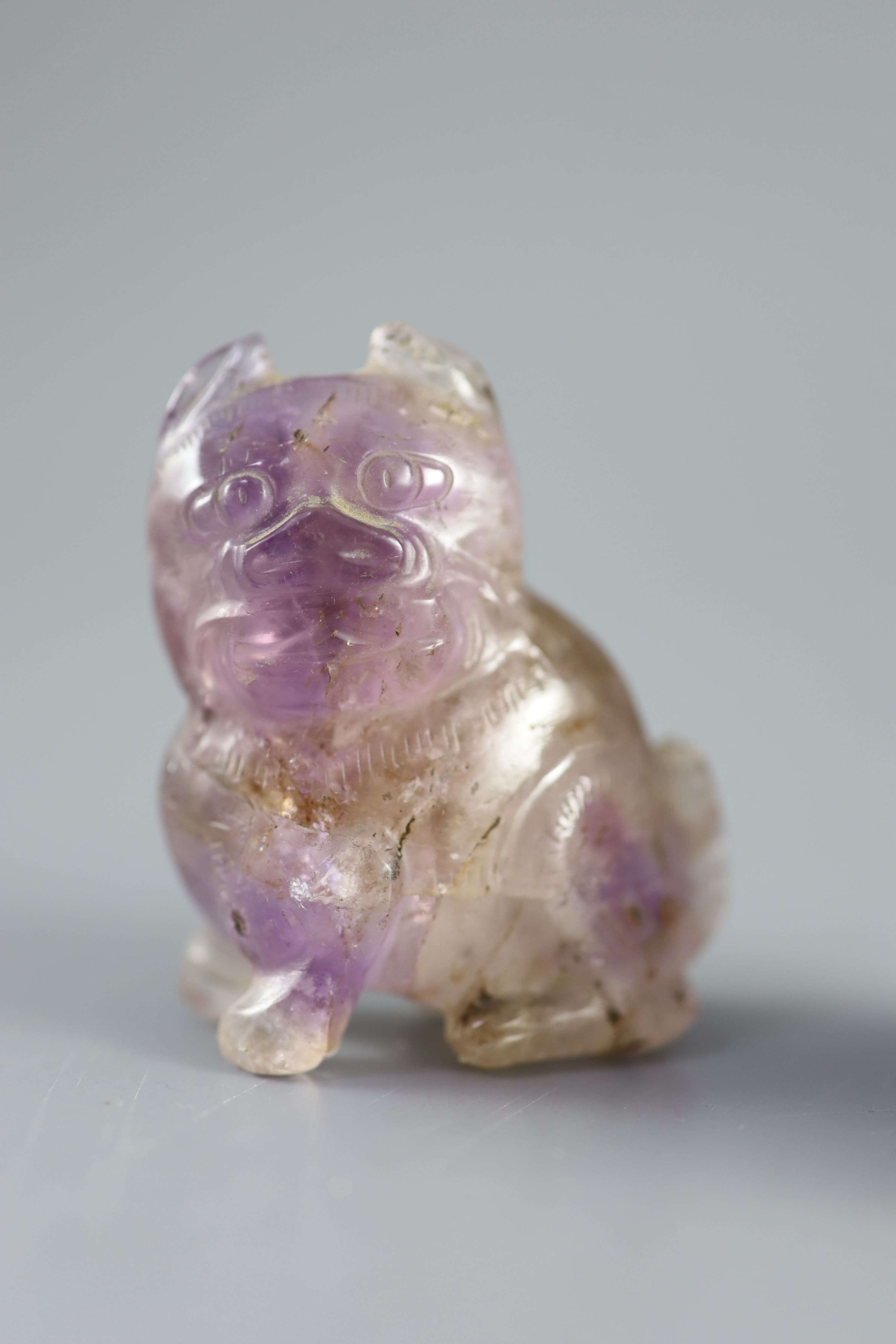 A Chinese amethyst rose quartz carving of a dog of Fo and a scent bottle and stopper, height 6.35cm and 5.1cm. (a.f.)